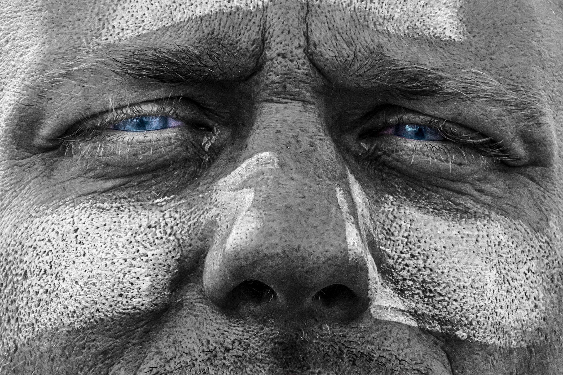 Très gros plan en noir et blanc d’un visage buriné, les yeux bleus conservés en couleur. Photographie « Star in the Eyes » d’Arthur Rimour.