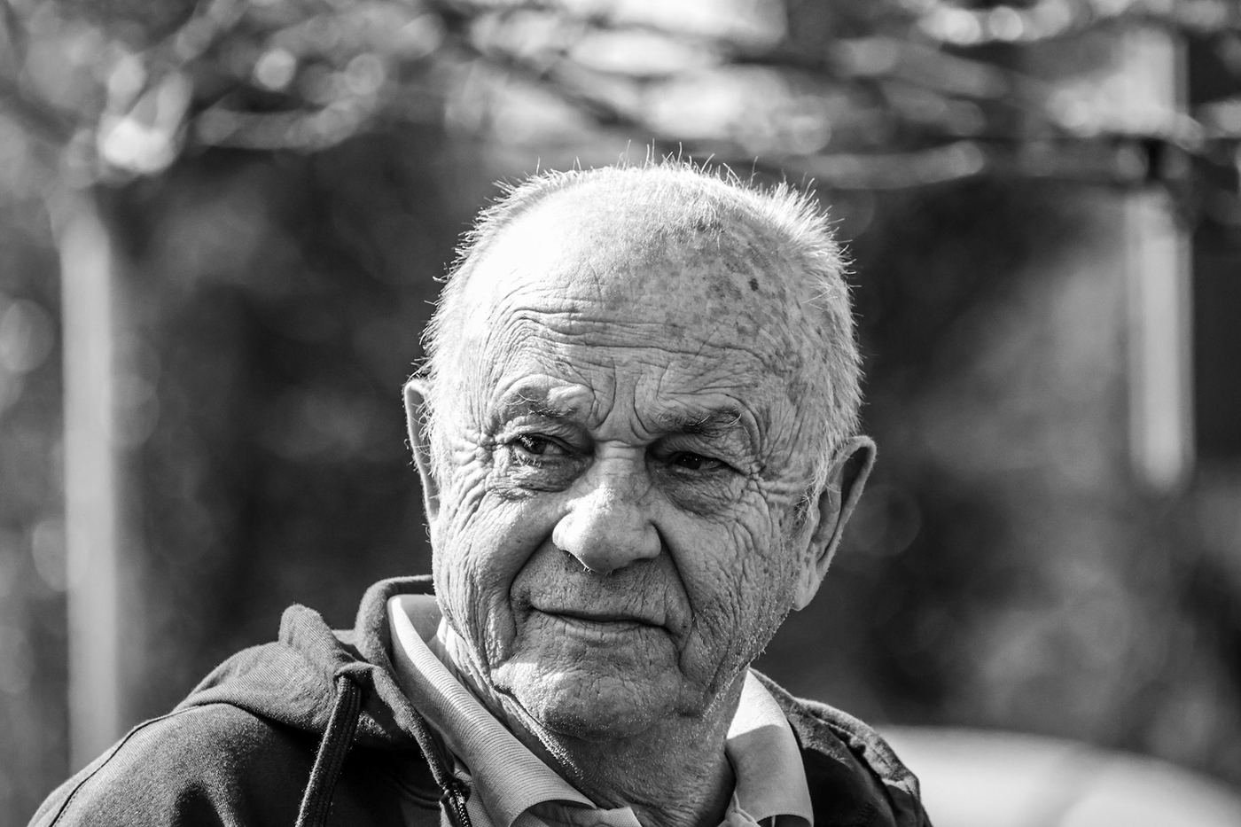 Portrait noir et blanc d’un homme âgé au bord du terrain.