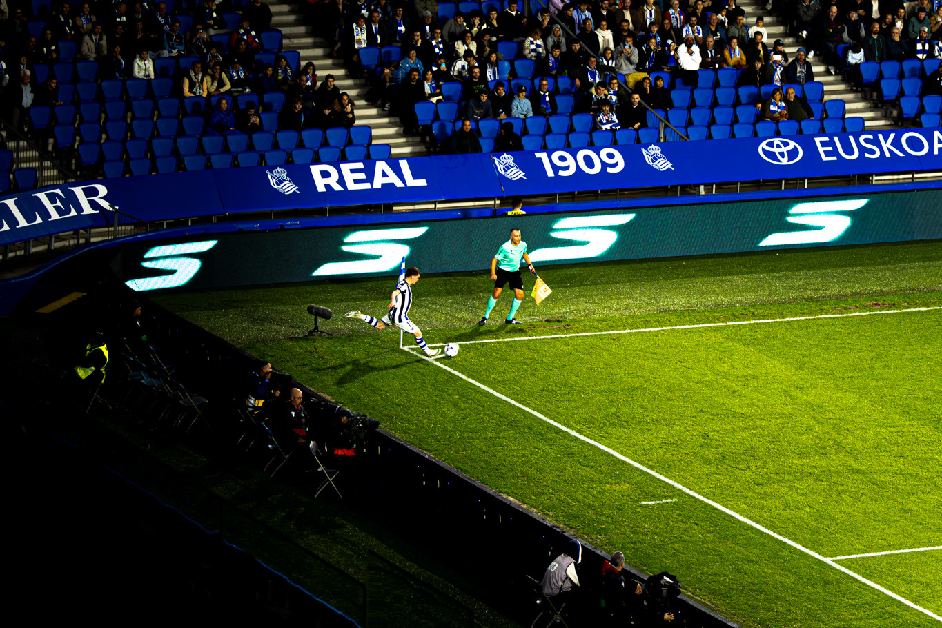 Un joueur de la Real Sociedad tire un corner sous les projecteurs d’Anoeta, devant les tribunes.